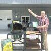 Dale Christensen is shown with his grand prize of a large Green Egg grill he won at the Open House demonstration at Jamesport Stove and Chimney.